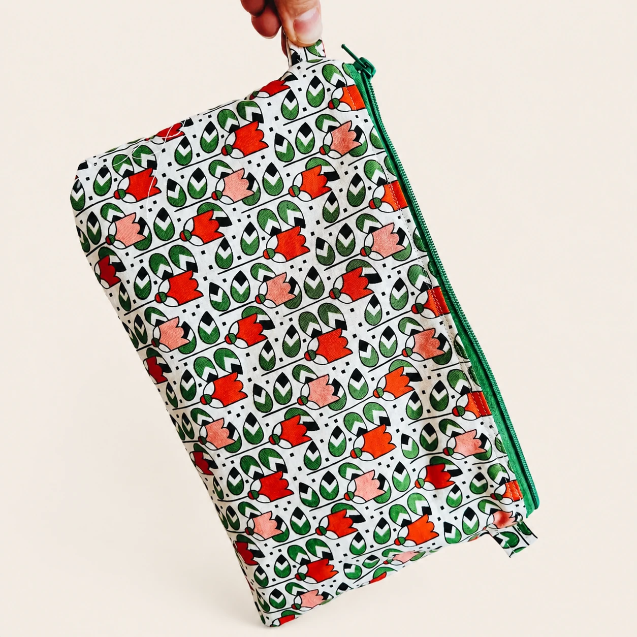Held view of the Floral Cotton Pouch showing its green zipper and coordinating side loops.