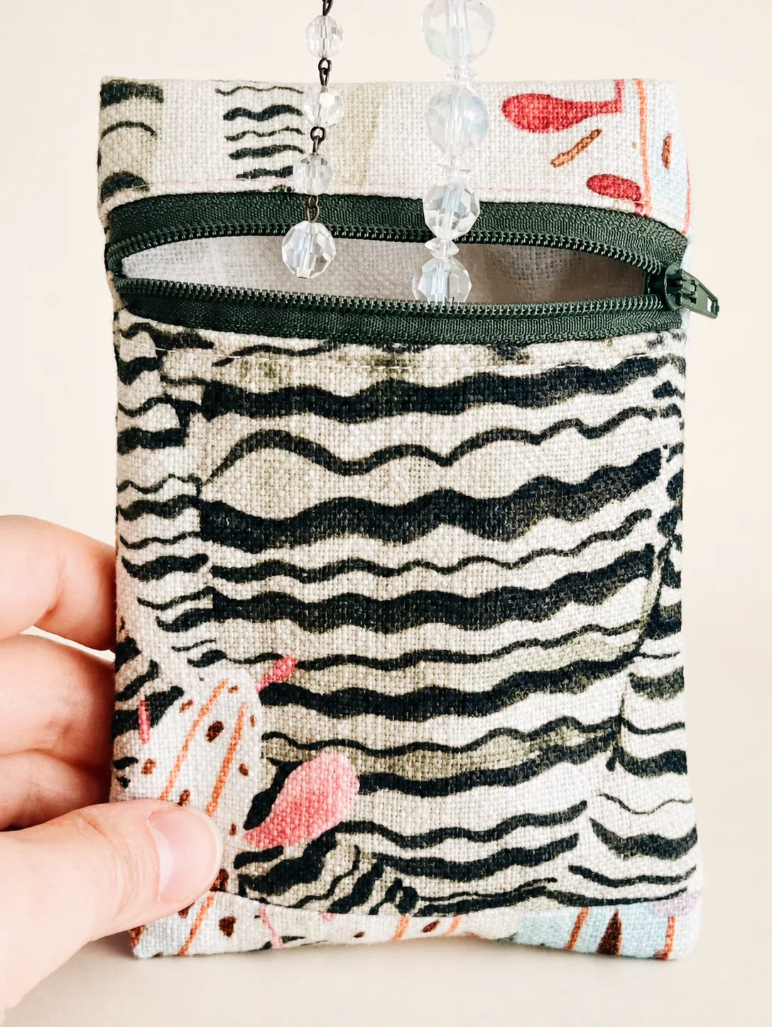 Sea Plants Jewelry Pouch held by hand beneath hanging crystal strands.