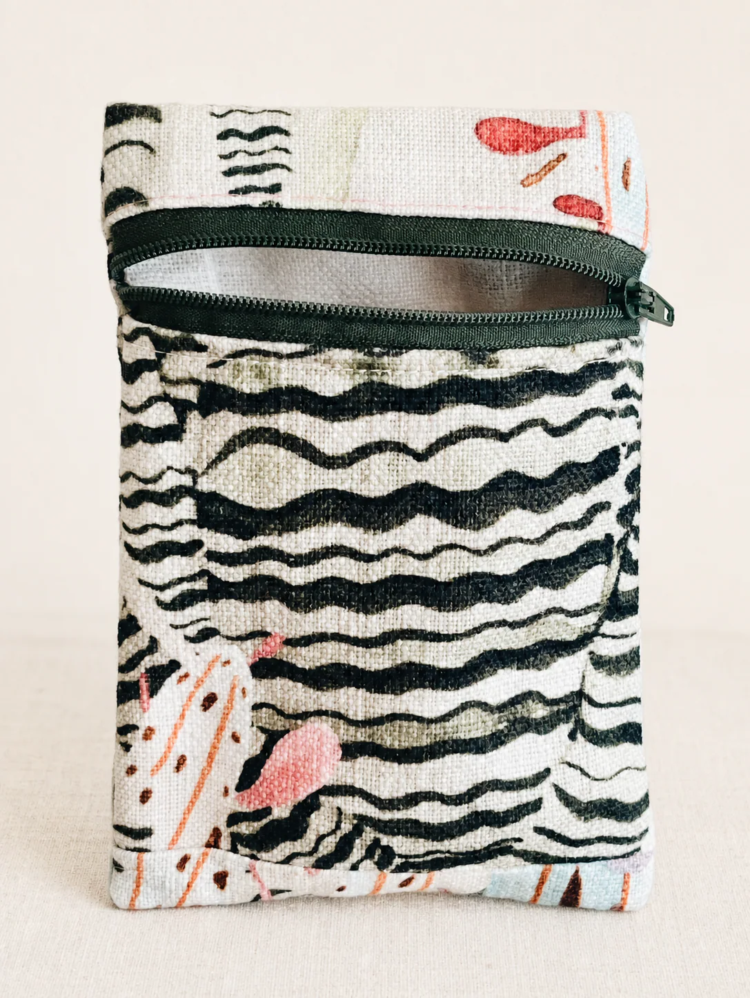 Sea Plants Jewelry Pouch with an open dark green zipper on a warm ivory background.
