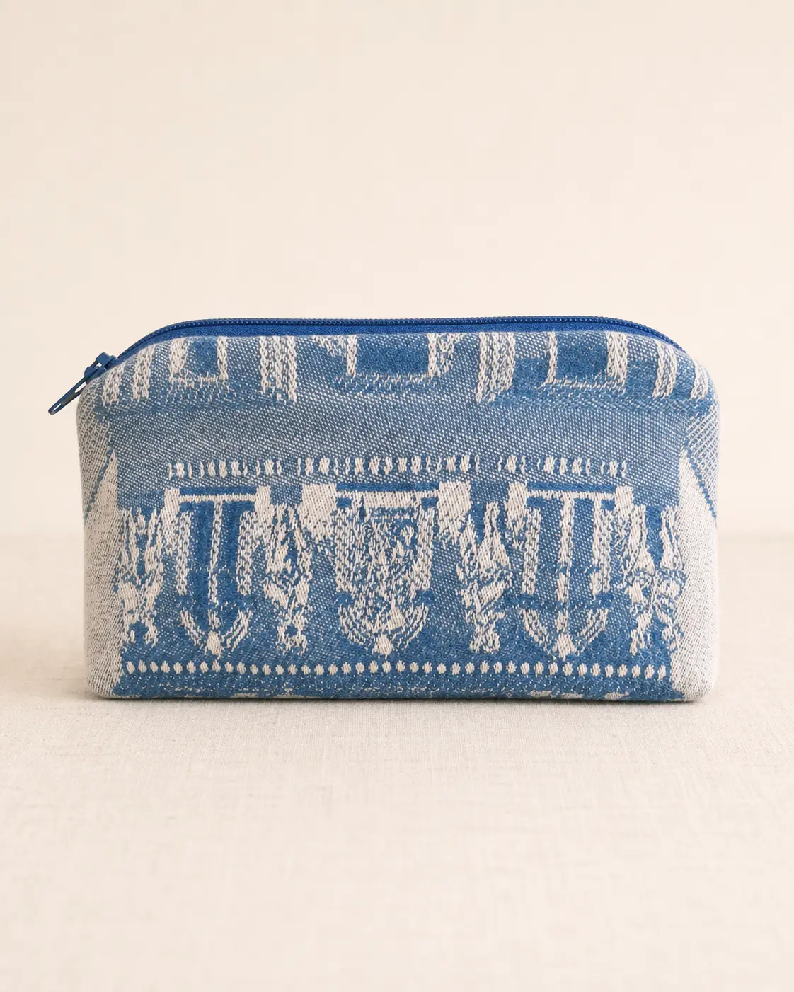 Reverse side of the blue and cream pouch showing another section of the woven architectural motif